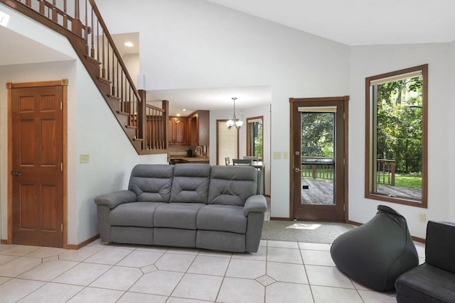 6500 E Decorah Ave, Oshkosh, WI 54902 - living room with stairway, a chandelier, baseboards, light tile patterned floors, and high vaulted ceiling