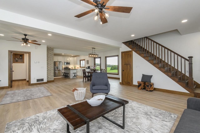 W6497 Vandre Rd, Johnson Creek, WI 53038 - living room featuring light wood-style flooring, a ceiling fan, stairs, baseboards, and recessed lighting