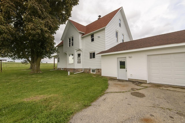 W6497 Vandre Rd, Johnson Creek, WI 53038 - view of side of home featuring a lawn, a shingled roof, asphalt driveway, a garage, and a chimney