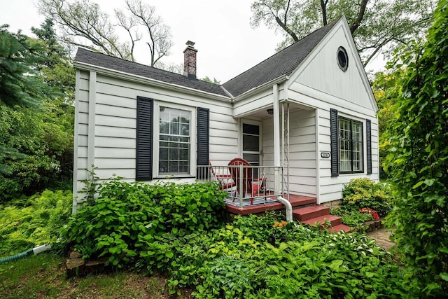 4730 N 106th St, Wauwatosa, WI 53225 - back of property featuring a chimney, roof with shingles, and a porch