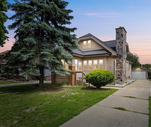 1472 S 86th St, West Allis, WI 53214 - view of front facade with a front lawn, a chimney, roof with shingles, an outdoor structure, and a detached garage