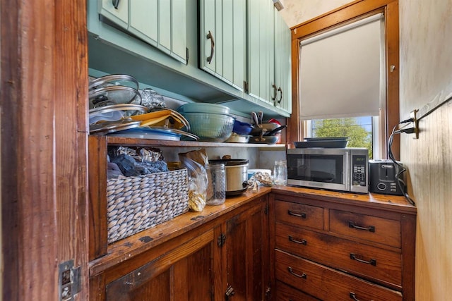 1472 S 86th St, West Allis, WI 53214 - kitchen view of stainless steel microwave, green cabinetry, and butcher block counters