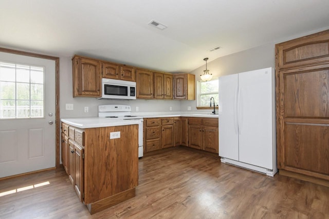 9219 Caddy Ln, Caledonia, WI 53108 - kitchen with white appliances, a sink, brown cabinets, lofted ceiling, and light countertops