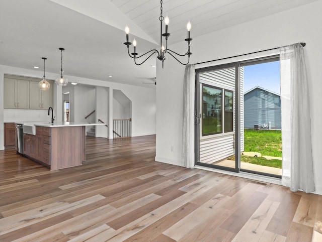 9437 Cobalt St, Middleton, WI 53562 - kitchen featuring open floor plan, light wood-type flooring, light countertops, vaulted ceiling, and a chandelier
