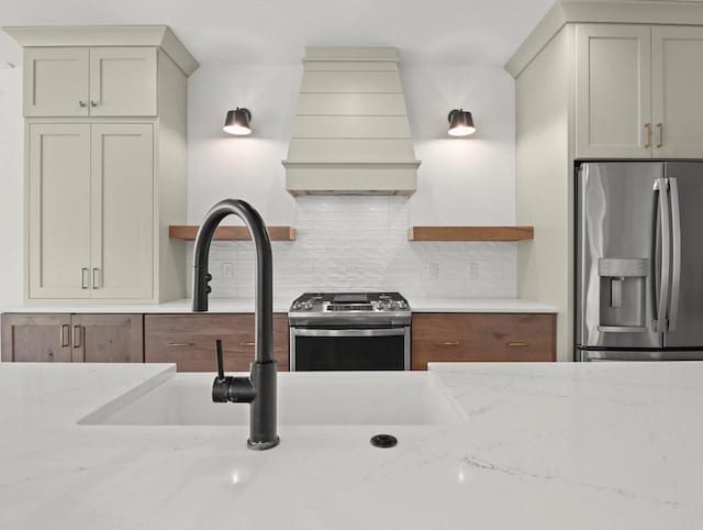 9437 Cobalt St, Middleton, WI 53562 - kitchen featuring appliances with stainless steel finishes, custom range hood, tasteful backsplash, and light stone counters
