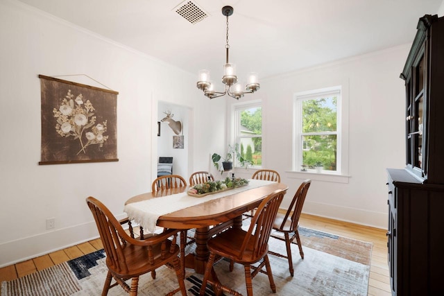 2205 Salisbury Rd, West Bend, WI 53090 - dining space featuring a chandelier, light wood finished floors, baseboards, and ornamental molding