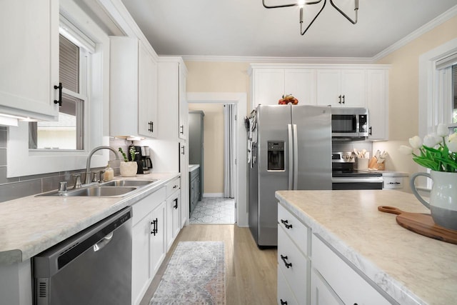 2205 Salisbury Rd, West Bend, WI 53090 - kitchen with appliances with stainless steel finishes, a sink, light wood-style flooring, white cabinetry, and light countertops