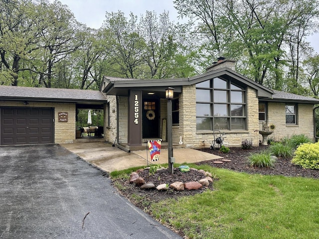 12554 Knoll Rd, Elm Grove, WI 53122 - mid-century home featuring a garage, a chimney, asphalt driveway, and stone siding
