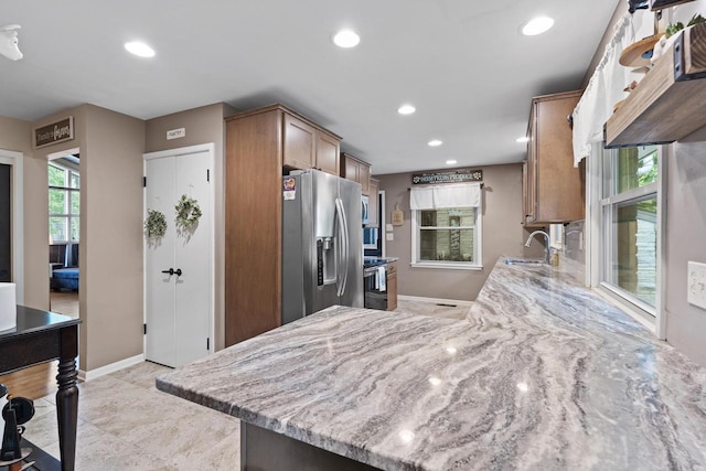 12554 Knoll Rd, Elm Grove, WI 53122 - kitchen featuring stainless steel refrigerator with ice dispenser, light stone countertops, recessed lighting, brown cabinets, and range