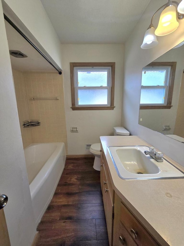 9829 W Lincoln Ave, West Allis, WI 53227 - full bathroom featuring wood finished floors, vanity, toilet, and plenty of natural light