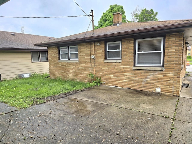 9829 W Lincoln Ave, West Allis, WI 53227 - back of house with a patio area, a chimney, and brick siding