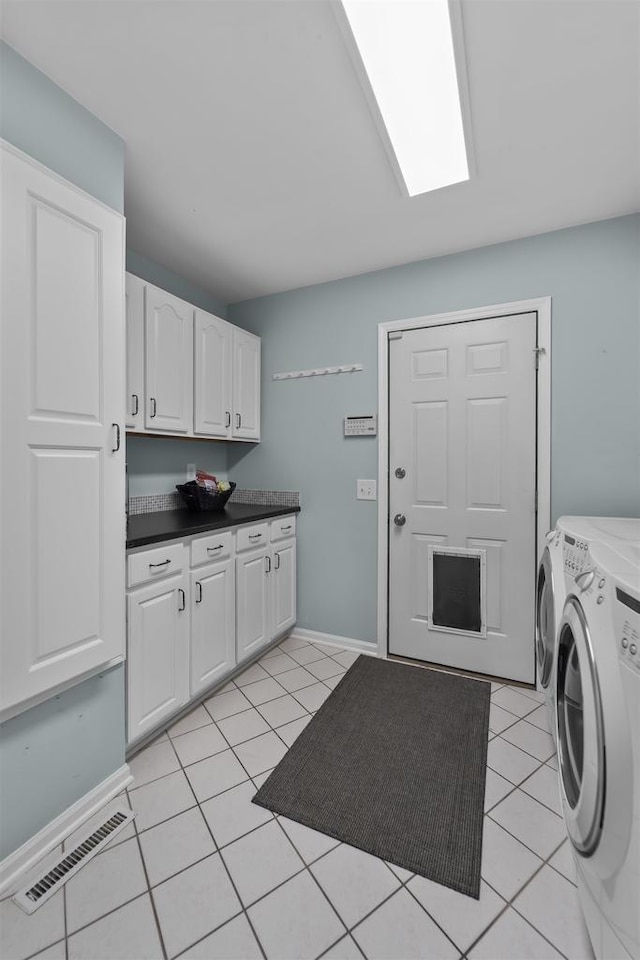 3948 Trempealeau Trl, Verona, WI 53593 - laundry room featuring washing machine and clothes dryer, cabinet space, light tile patterned floors, and baseboards