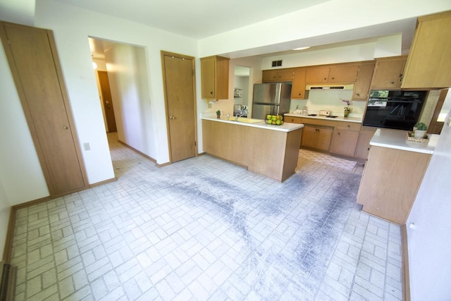 8680 N Point Dr, Fox Point, WI 53217 - kitchen with freestanding refrigerator, oven, brick patterned floors, cooktop, and a peninsula