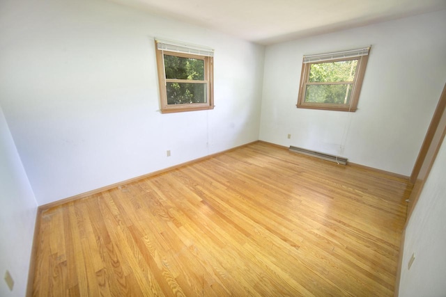 8680 N Point Dr, Fox Point, WI 53217 - unfurnished room featuring baseboard heating, light wood-type flooring, and baseboards