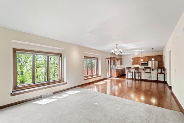 100 Accipiter Ct, Burlington, WI 53105 - living area featuring a chandelier, dark colored carpet, baseboards, and dark wood-style floors