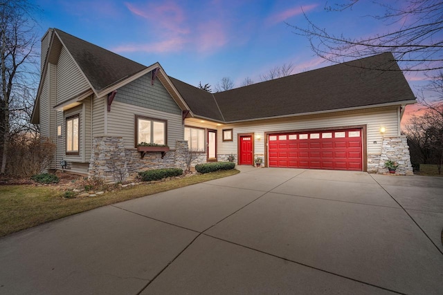 100 Accipiter Ct, Burlington, WI 53105 - view of front facade with stone siding, concrete driveway, an attached garage, and roof with shingles