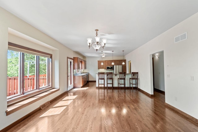 100 Accipiter Ct, Burlington, WI 53105 - living area featuring wood finished floors, a chandelier, and baseboards