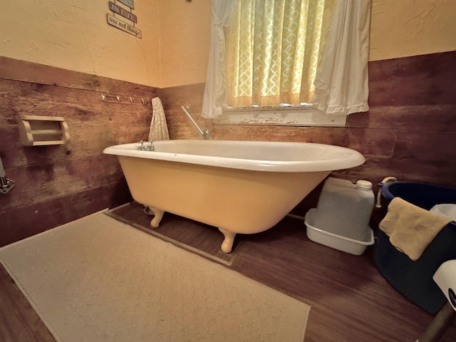1657 N Elm Rd, Junction City, WI 54443 - bathroom with a soaking tub, wood finished floors, wood walls, a textured wall, and a wainscoted wall