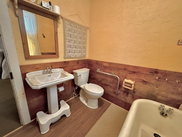 1657 N Elm Rd, Junction City, WI 54443 - full bath featuring a soaking tub, wood finished floors, toilet, and wainscoting