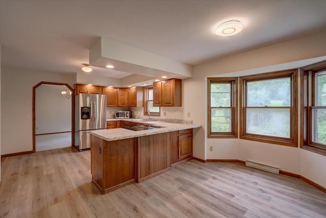 1230 N Westfield Rd, Madison, WI 53717 - kitchen with stainless steel appliances, a peninsula, brown cabinetry, light countertops, and light wood-type flooring