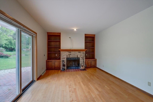 1230 N Westfield Rd, Madison, WI 53717 - unfurnished living room featuring light wood-style flooring, a brick fireplace, and built in shelves