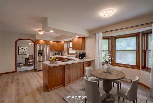 1230 N Westfield Rd, Madison, WI 53717 - kitchen featuring stainless steel appliances, brown cabinets, light countertops, a peninsula, and light wood-style floors