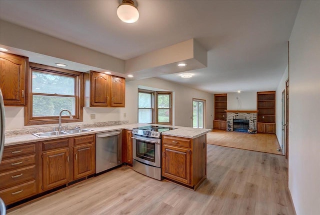 1230 N Westfield Rd, Madison, WI 53717 - kitchen featuring appliances with stainless steel finishes, a peninsula, light wood-style flooring, brown cabinets, and healthy amount of natural light