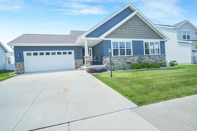 951 Lavender Way, Deforest, WI 53532 - craftsman house with stone siding, a front yard, a garage, driveway, and covered porch