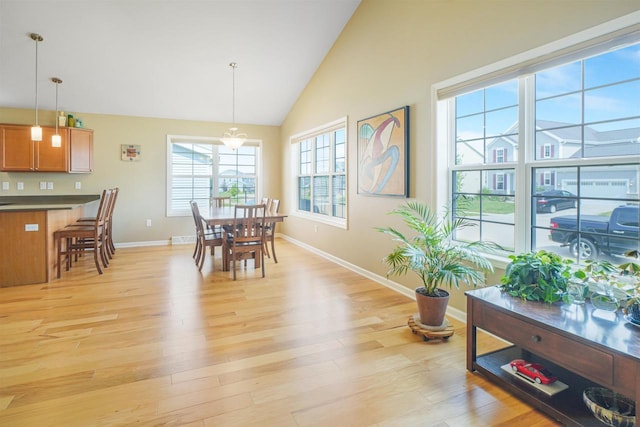 951 Lavender Way, Deforest, WI 53532 - dining area with baseboards, light wood-style floors, and high vaulted ceiling