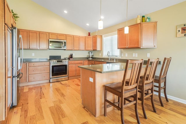 951 Lavender Way, Deforest, WI 53532 - kitchen featuring appliances with stainless steel finishes, a peninsula, a breakfast bar area, light wood-type flooring, and lofted ceiling