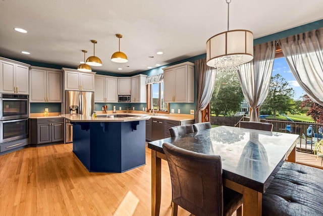 W4745 Briar Dr, Elkhorn, WI 53121 - kitchen with appliances with stainless steel finishes, light countertops, a center island, a kitchen bar, and plenty of natural light