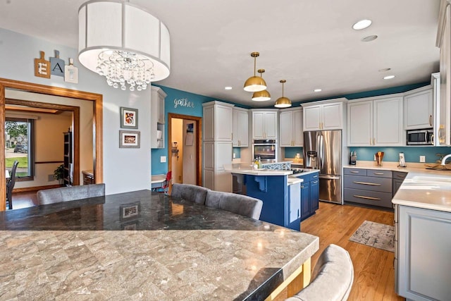 W4745 Briar Dr, Elkhorn, WI 53121 - kitchen with appliances with stainless steel finishes, a kitchen bar, a kitchen island, a sink, and light wood-type flooring
