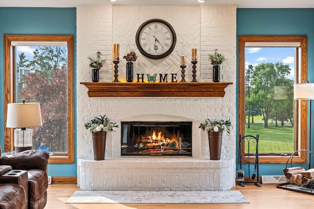 W4745 Briar Dr, Elkhorn, WI 53121 - living area featuring wood finished floors, baseboards, a brick fireplace, and healthy amount of natural light