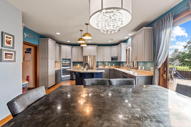 W4745 Briar Dr, Elkhorn, WI 53121 - kitchen with stainless steel appliances, a center island, decorative light fixtures, a sink, and gray cabinetry