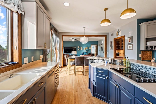 W4745 Briar Dr, Elkhorn, WI 53121 - kitchen featuring black electric stovetop, plenty of natural light, blue cabinets, and light wood-style flooring