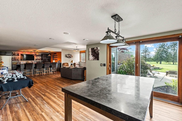 W4745 Briar Dr, Elkhorn, WI 53121 - dining area featuring a textured ceiling, light wood-style flooring, plenty of natural light, and a chandelier