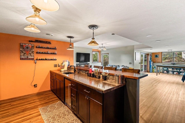 W4745 Briar Dr, Elkhorn, WI 53121 - kitchen featuring beverage cooler, a sink, a peninsula, open floor plan, and light wood finished floors