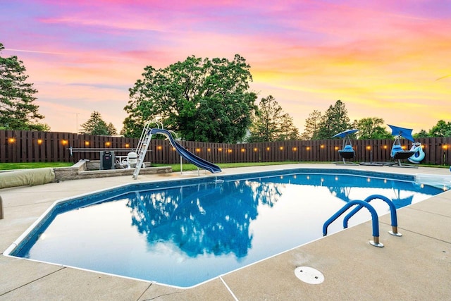 W4745 Briar Dr, Elkhorn, WI 53121 - pool at dusk featuring a water slide and a fenced backyard