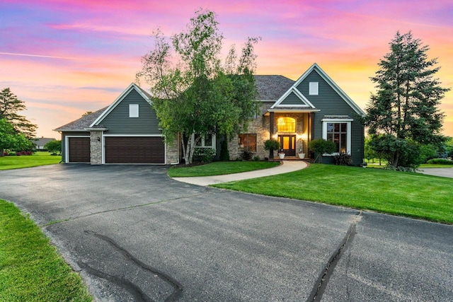 W4745 Briar Dr, Elkhorn, WI 53121 - traditional-style home with a lawn, a garage, driveway, and stone siding