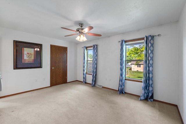 136 Yacoub Ln, Fond Du Lac, WI 54935 - empty room featuring healthy amount of natural light, light carpet, ceiling fan, and baseboards