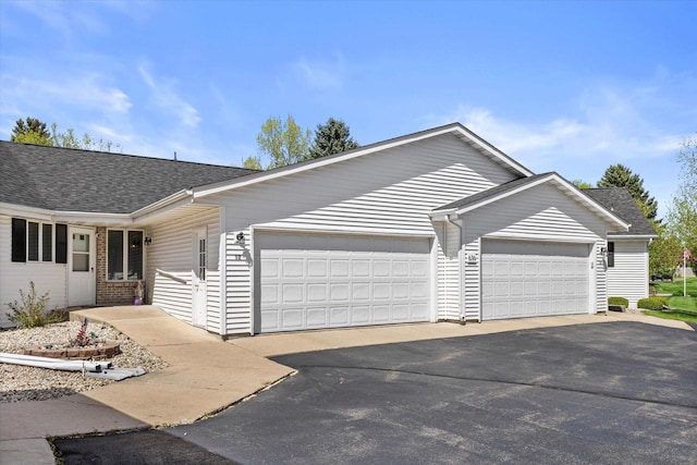 636 Westbury Ln Unit 12, Delavan, WI 53115 - ranch-style home featuring a garage, driveway, and roof with shingles