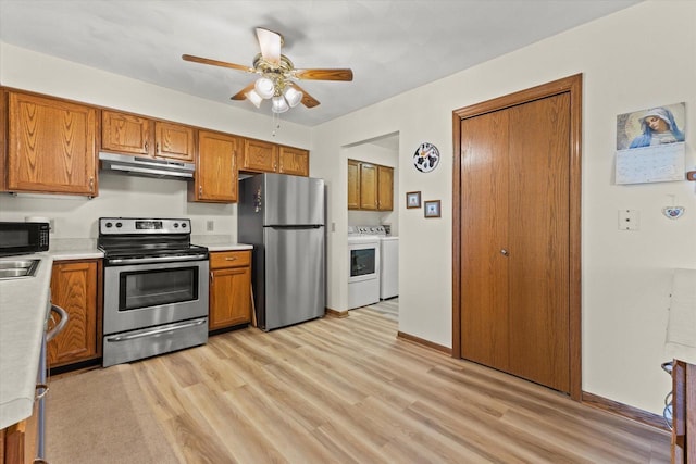 636 Westbury Ln Unit 12, Delavan, WI 53115 - kitchen featuring appliances with stainless steel finishes, washer and dryer, under cabinet range hood, and light countertops