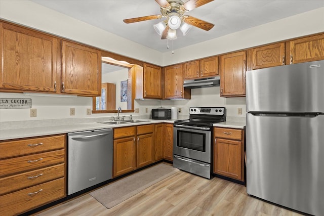 636 Westbury Ln Unit 12, Delavan, WI 53115 - kitchen featuring stainless steel appliances, under cabinet range hood, a sink, and brown cabinets