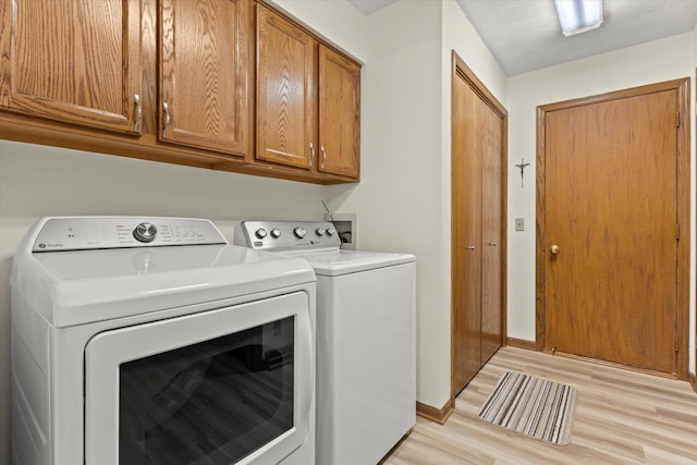 636 Westbury Ln Unit 12, Delavan, WI 53115 - laundry room with washer and dryer, light wood-style flooring, cabinet space, and baseboards