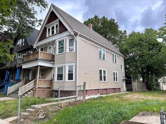 1950 N 40th St Unit 1952, Milwaukee, WI 53208 - view of side of home with a chimney, a balcony, a shingled roof, and covered porch