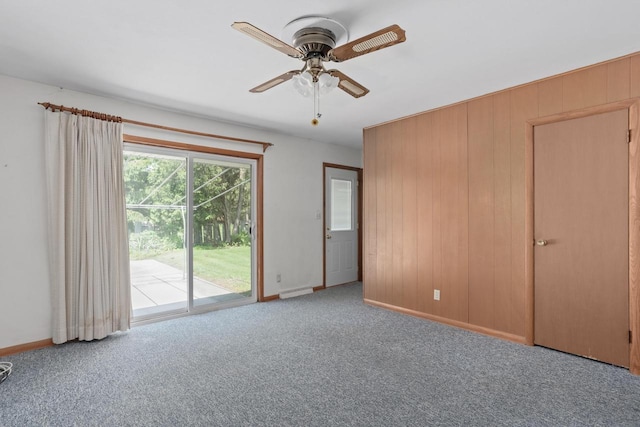 11549 N Meadowbrook Dr, Mequon, WI 53097 - unfurnished bedroom featuring access to outside, baseboards, carpet floors, wooden walls, and ceiling fan