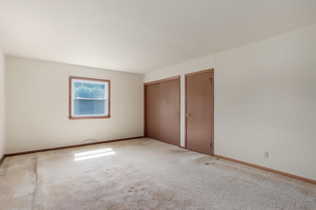 11549 N Meadowbrook Dr, Mequon, WI 53097 - unfurnished bedroom with multiple closets, baseboards, and carpet floors