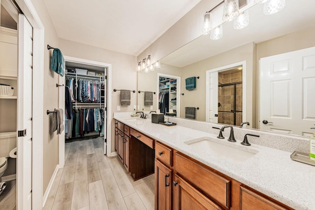 15370 Huff Way, Brookfield, WI 53005 - bathroom with a spacious closet, double vanity, toilet, a shower stall, and wood finished floors