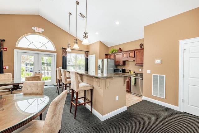 15370 Huff Way, Brookfield, WI 53005 - kitchen with stainless steel appliances, a breakfast bar area, french doors, light carpet, and high vaulted ceiling