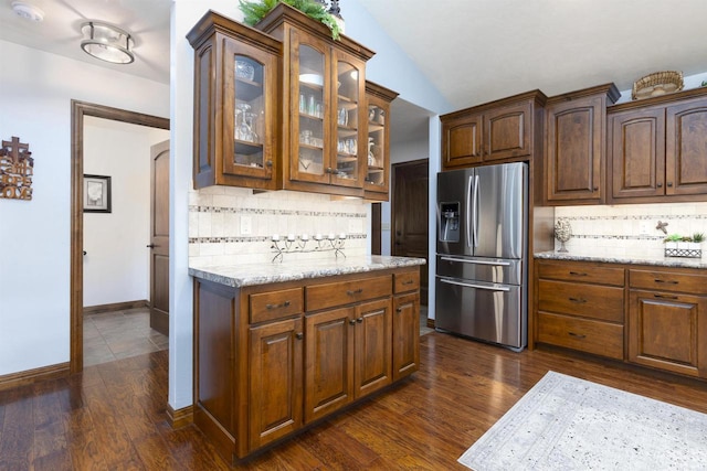 938 W Northstar Dr, Appleton, WI 54913 - kitchen featuring stainless steel fridge with ice dispenser, decorative backsplash, glass insert cabinets, lofted ceiling, and dark wood-style flooring